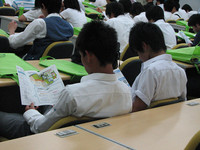 資料に目をとおす参加者